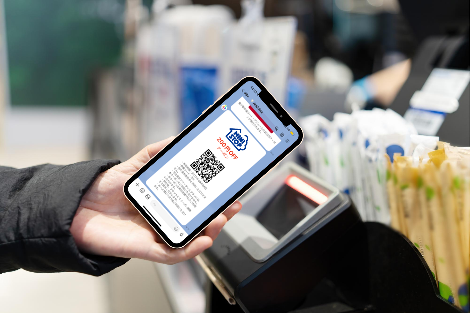 A person using a mobile phone to make a payment at convenience store